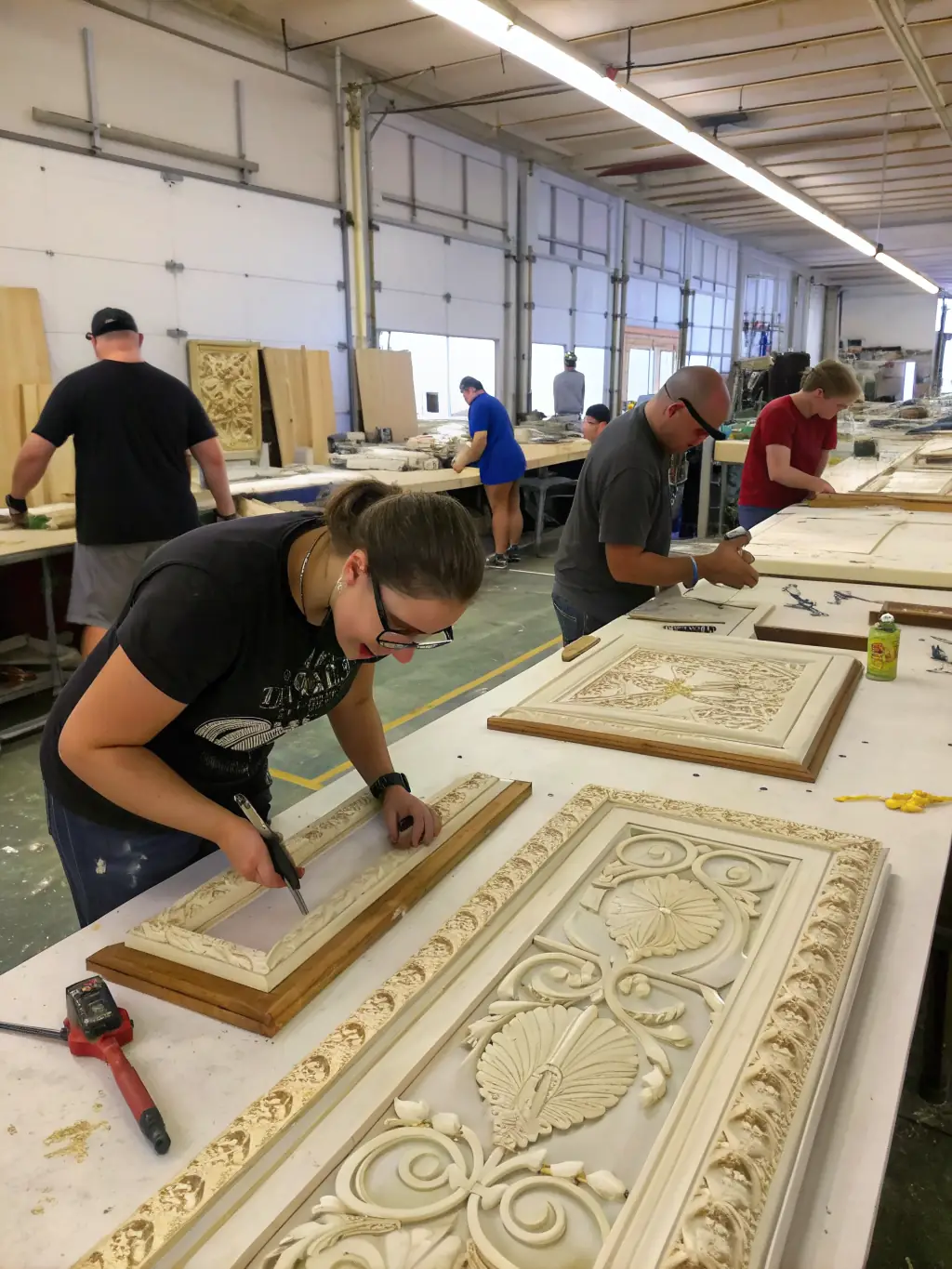 Volunteers working together to restore a wooden sailing boat, using traditional tools and techniques. The setting is a workshop filled with equipment and materials.